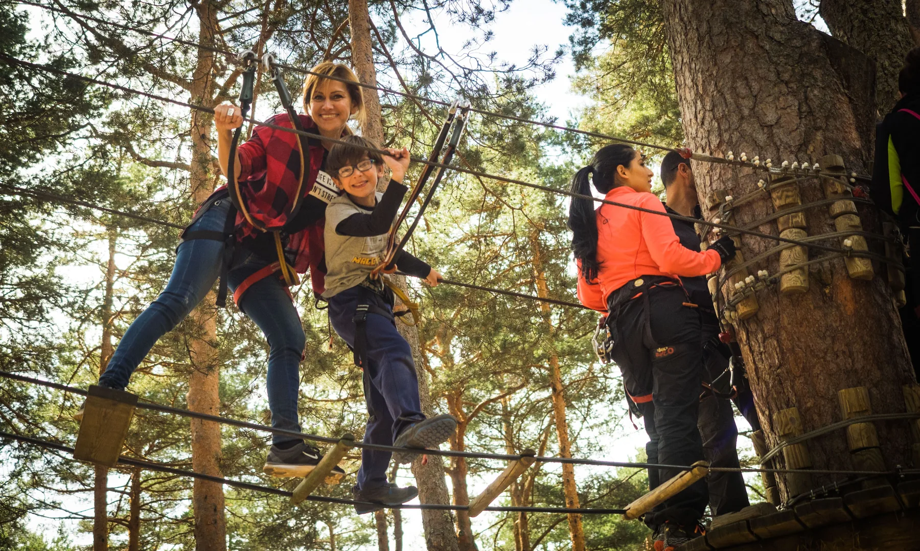 Une mère et son enfant sur un parcours accrobranche en forêt