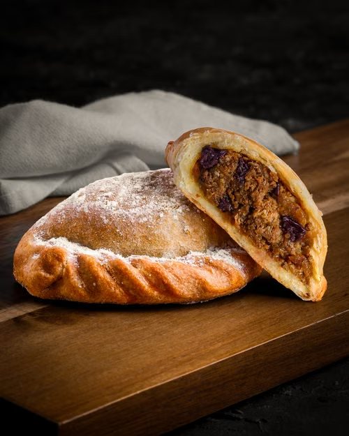 Cornish pasty coupé en deux sur une planche