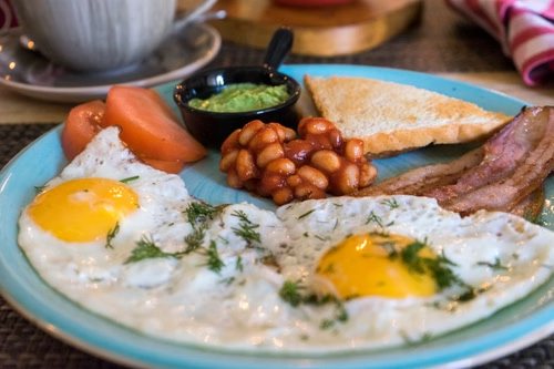 Assiette de full English breakfast avec œufs, bacon et baked beans