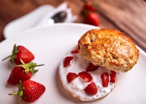 Scone servi avec crème et fraises pour le tea time